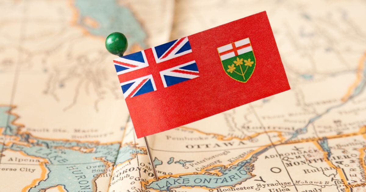 A pin holding a flag of Ontario on a map of Ontario.